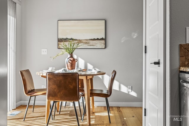 dining room with baseboards and wood finished floors