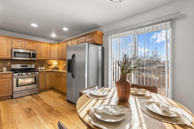 kitchen featuring recessed lighting, light wood-type flooring, stainless steel appliances, decorative backsplash, and light stone countertops