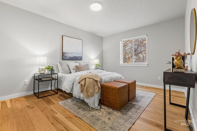 bedroom featuring baseboards and light wood finished floors