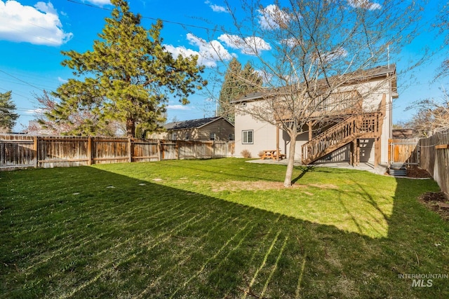 view of yard with stairs and a fenced backyard