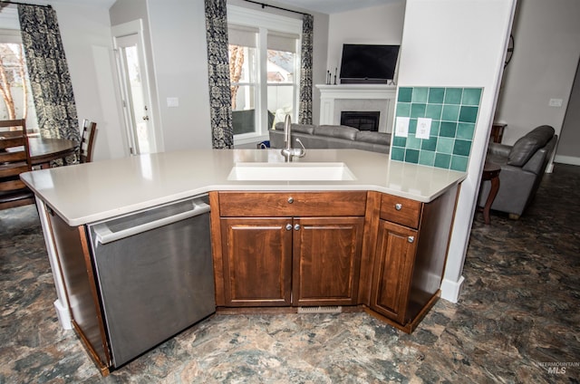 kitchen with stainless steel dishwasher, sink, and backsplash