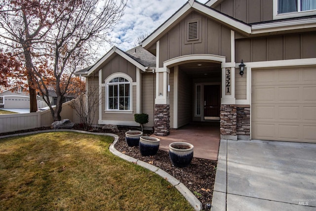 entrance to property featuring a yard and a garage