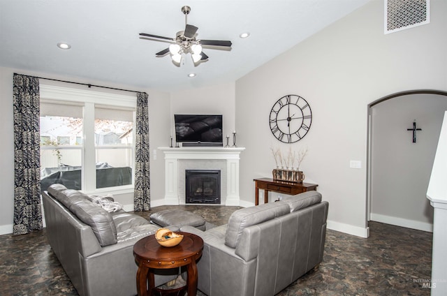 living room featuring ceiling fan, a brick fireplace, and lofted ceiling