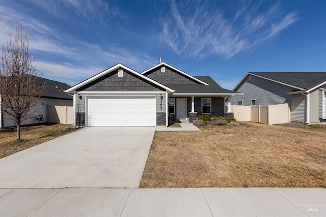 craftsman inspired home featuring an attached garage, fence, stone siding, and driveway