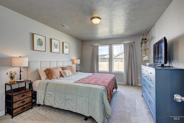 bedroom featuring visible vents, light carpet, a textured ceiling, and baseboards