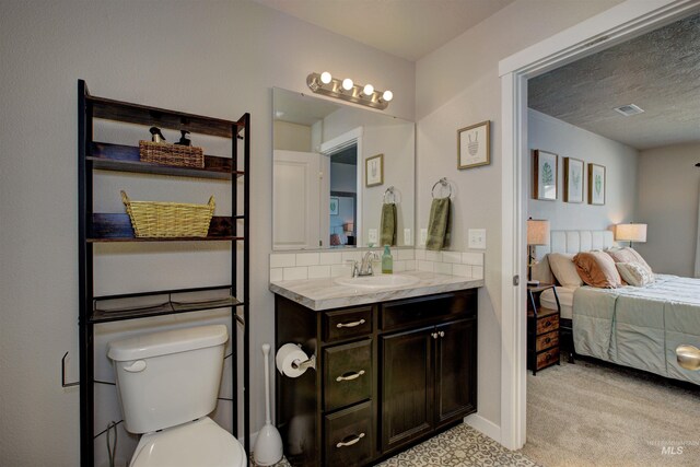 bathroom featuring visible vents, connected bathroom, toilet, decorative backsplash, and vanity