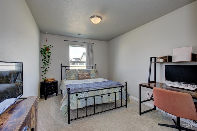 bedroom featuring visible vents, carpet floors, and a textured ceiling