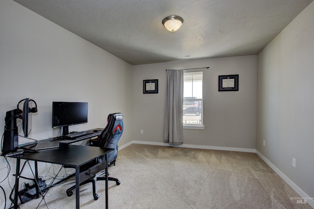 carpeted office with visible vents, a textured ceiling, and baseboards