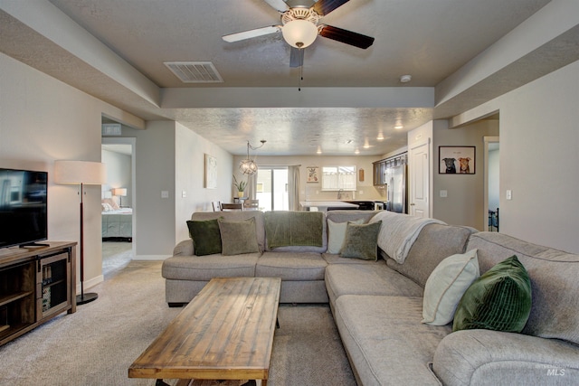 living room with baseboards, visible vents, a textured ceiling, light carpet, and ceiling fan with notable chandelier