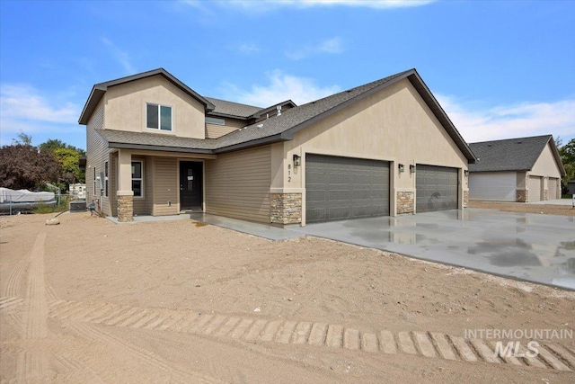 view of front of home with stucco siding, concrete driveway, an attached garage, central AC unit, and stone siding