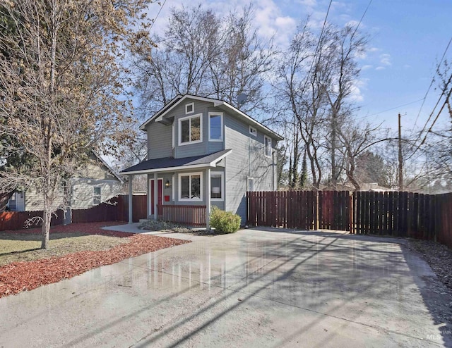 view of front of home featuring covered porch and fence