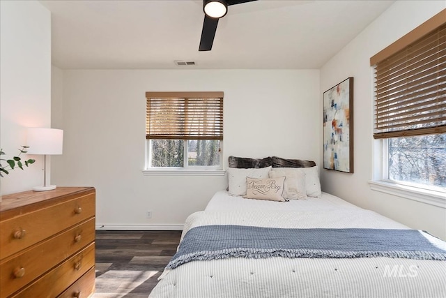 bedroom featuring visible vents, multiple windows, baseboards, and dark wood finished floors