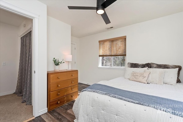 bedroom featuring visible vents, baseboards, dark wood-type flooring, and ceiling fan