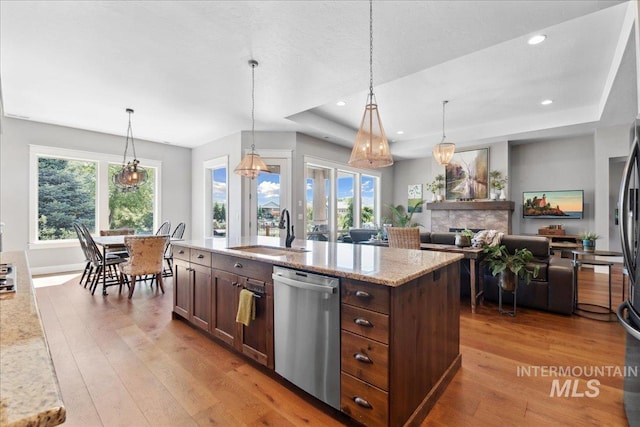 92 S Wildgrass Way, Star, ID 83669 - kitchen featuring dishwasher, wood-type flooring, a raised ceiling, a sink, and light stone counters
