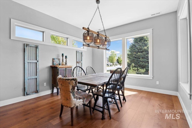 92 S Wildgrass Way, Star, ID 83669 - dining room featuring healthy amount of natural light, hardwood / wood-style floors, a chandelier, and baseboards