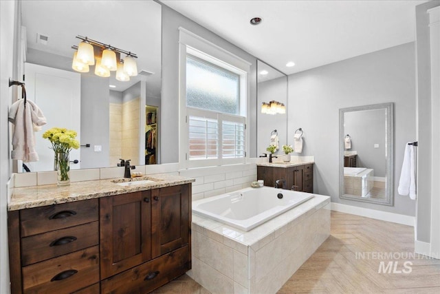 92 S Wildgrass Way, Star, ID 83669 - full bath with a garden tub, two vanities, a walk in closet, recessed lighting, and baseboards