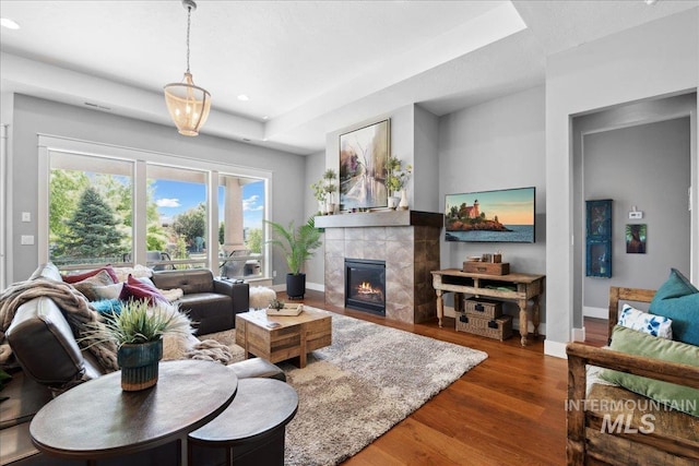 92 S Wildgrass Way, Star, ID 83669 - living room with baseboards, a tiled fireplace, wood finished floors, recessed lighting, and a tray ceiling