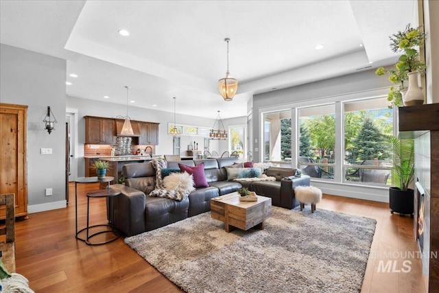 92 S Wildgrass Way, Star, ID 83669 - living area with a tray ceiling, recessed lighting, wood finished floors, and baseboards