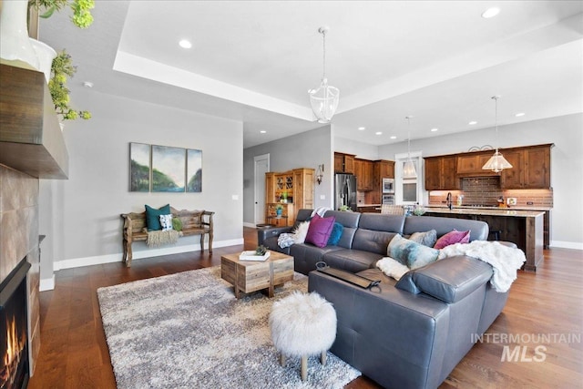 92 S Wildgrass Way, Star, ID 83669 - living area featuring recessed lighting, dark wood-style floors, a lit fireplace, and baseboards