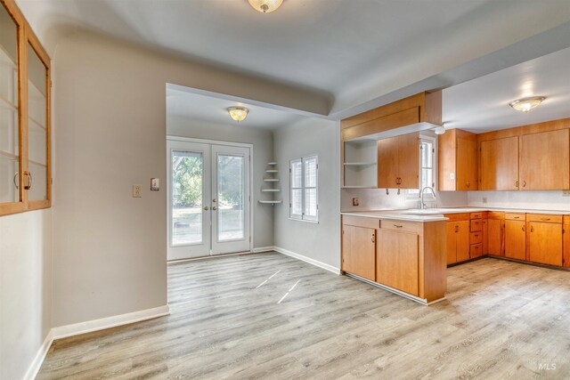 unfurnished living room featuring a brick fireplace, a textured ceiling, and light hardwood / wood-style floors