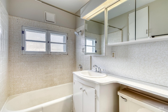 full bathroom featuring tiled shower / bath combo, vanity, toilet, and tasteful backsplash