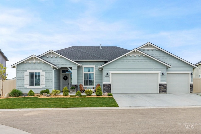 craftsman house with an attached garage, concrete driveway, a front lawn, and stone siding