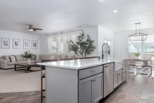 kitchen with gray cabinets, dishwasher, a sink, light countertops, and open floor plan