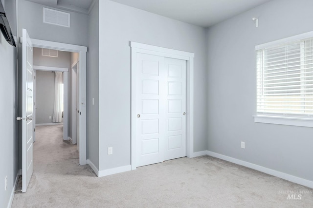 unfurnished bedroom featuring visible vents, baseboards, carpet floors, and a closet