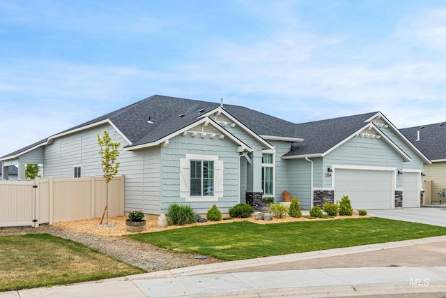 view of front of house with a shingled roof, fence, an attached garage, and driveway