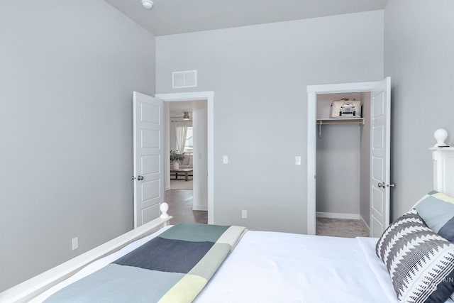 bedroom with visible vents, baseboards, a walk in closet, and a closet