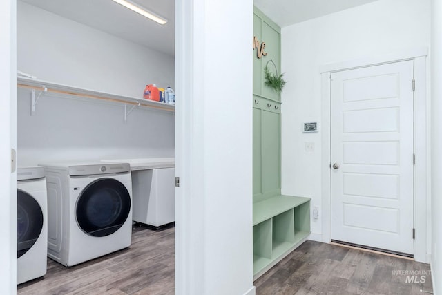 laundry area with laundry area, washing machine and dryer, and wood finished floors