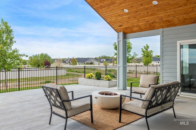 view of patio with a residential view, a fire pit, and a fenced backyard