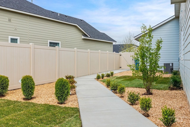 view of yard with central AC unit and fence
