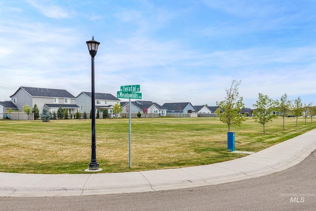 view of property's community featuring a yard, fence, and a residential view