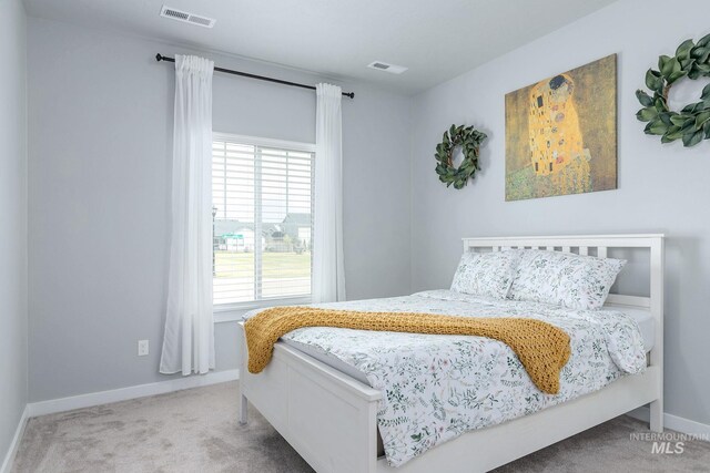 bedroom featuring baseboards, visible vents, and carpet