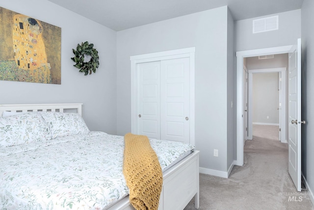 bedroom featuring visible vents, baseboards, a closet, and light colored carpet