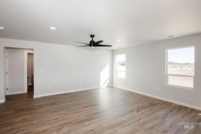 empty room featuring wood finished floors, a ceiling fan, baseboards, and recessed lighting