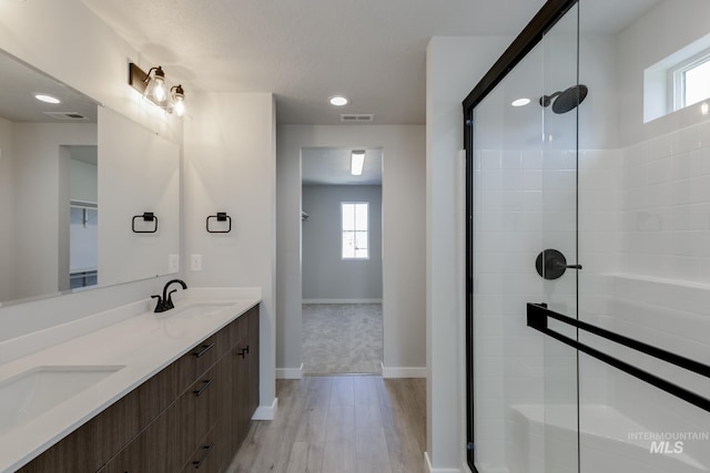 3121 S Carie Ave, Boise, ID 83709 - bathroom featuring wood finished floors, a stall shower, double vanity, plenty of natural light, and recessed lighting