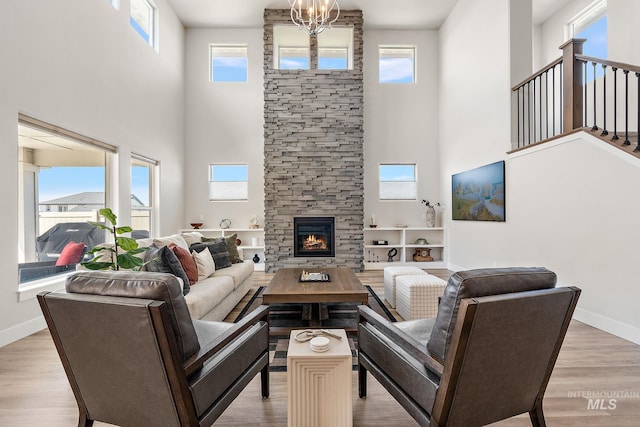 6071 S Pioneer Trail Way, Meridian, ID 83642 - living room featuring a towering ceiling, light wood-style floors, a stone fireplace, and a chandelier
