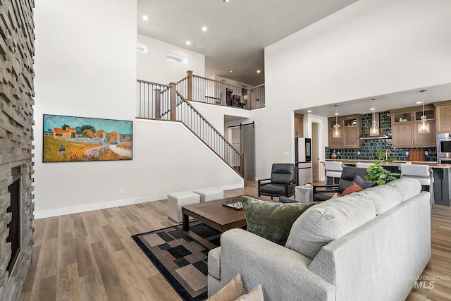 6071 S Pioneer Trail Way, Meridian, ID 83642 - living area featuring a towering ceiling, recessed lighting, a barn door, light wood-type flooring, and stairway