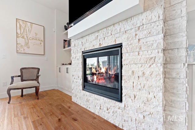 6706 Big Wood Way, Star, ID 83669 - living area featuring wood finished floors, a stone fireplace, and baseboards