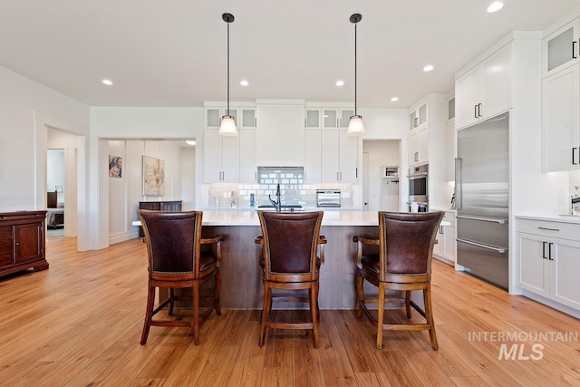 6706 Big Wood Way, Star, ID 83669 - kitchen featuring stainless steel appliances, light countertops, light wood-style flooring, a center island, and recessed lighting