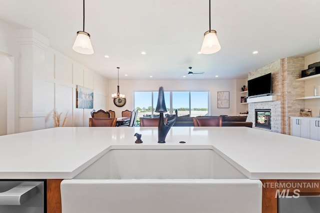 6706 Big Wood Way, Star, ID 83669 - kitchen with a sink, stainless steel dishwasher, a fireplace, light countertops, and hanging light fixtures