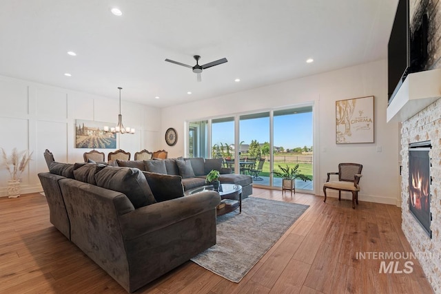 6706 Big Wood Way, Star, ID 83669 - living room featuring a fireplace, a ceiling fan, a chandelier, light wood finished floors, and recessed lighting