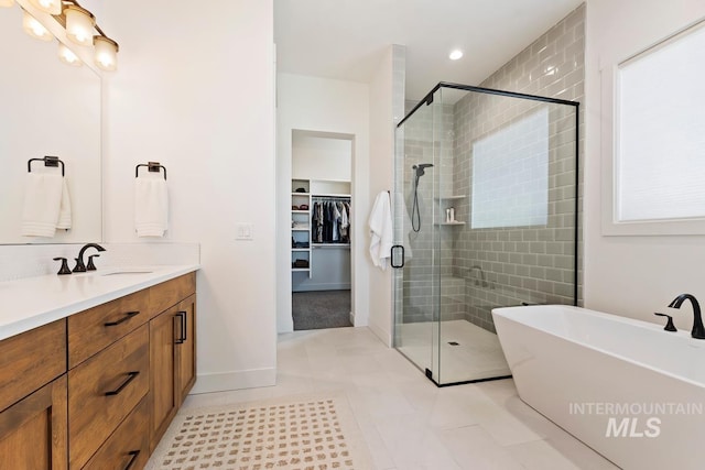 6706 Big Wood Way, Star, ID 83669 - full bath with vanity, a stall shower, a soaking tub, a walk in closet, and recessed lighting