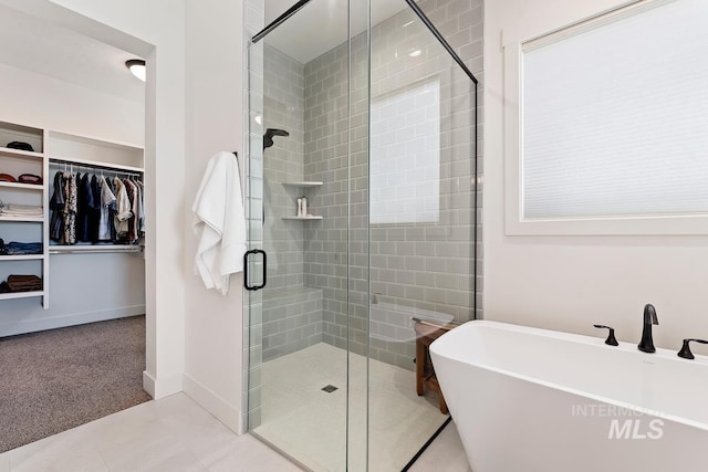 6706 Big Wood Way, Star, ID 83669 - bathroom featuring a soaking tub, a walk in closet, a shower stall, tile patterned flooring, and a sink