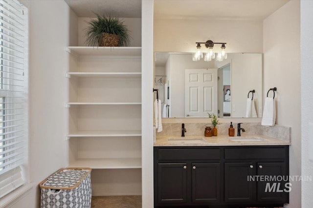 bathroom featuring a notable chandelier, a sink, and double vanity