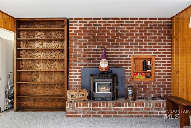 room details featuring wooden walls, carpet flooring, and a wood stove