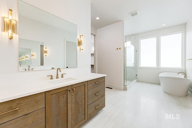 full bathroom with visible vents, a freestanding bath, a stall shower, vanity, and baseboards
