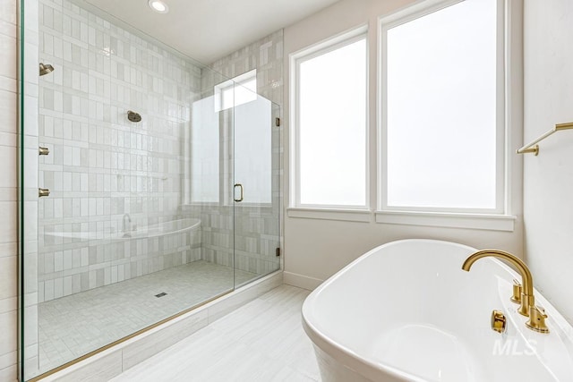 full bathroom with a soaking tub, a shower stall, and recessed lighting